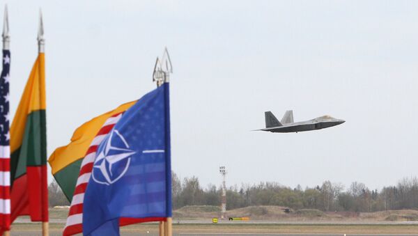 A US Air Force F-22 Raptor fighter aircraft flies at the Air Base of the Lithuanian Armed Forces in Šiauliai, Lithuania, on April 27, 2016 behind flags of US, Lithiania and the NATO - Sputnik Brasil