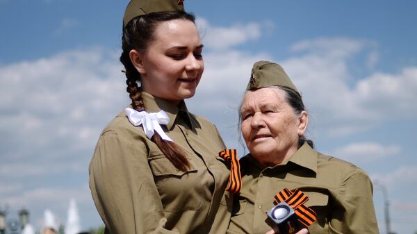 Menina dança com veterana de guerra na festa em comemoração dos 71 anos da Vitória na Grande Guerra pela Pátria, em Moscou. Rússia, 9 de maio de 2016 - Sputnik Brasil