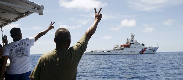 Soldados filipinos apontam em um navio chinês da Guarda Costeira perto das Ilhas Spratly, no mar do Sul da China - Sputnik Brasil