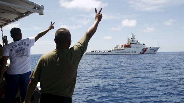 Soldados filipinos apontam em um navio chinês da Guarda Costeira perto das Ilhas Spratly, no mar do Sul da China - Sputnik Brasil