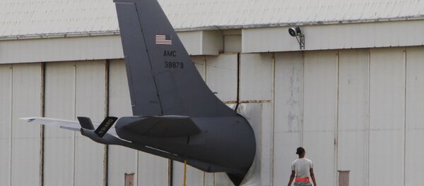 A ground crew member walks towards the tail of a U.S. Air Force KC-135 Stratotanker protruding from a hanger at Kadena Air Base on Japan's southwestern island of Okinawa (File) - Sputnik Brasil