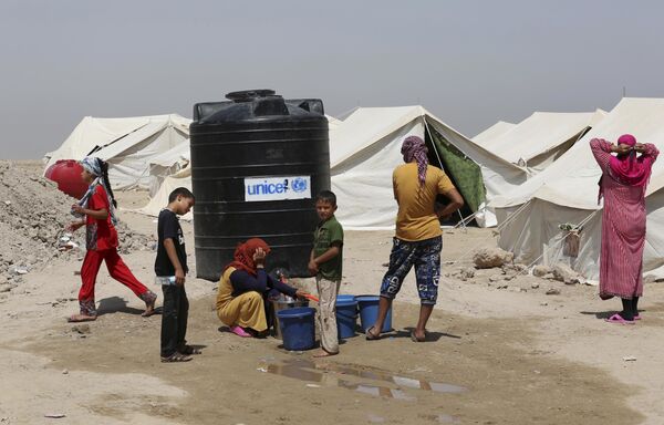 Esta foto de 25 de junho de 2016 mostra um grupo de iraquianos anteriormente residentes em Fallujah em um campo de refugiados. A saída em massa da cidade, então ocupada pelo Daesh, foi pedida pelas forças governamentais do Iraque antes de começar a ofensiva que libertou Fallujah - Sputnik Brasil