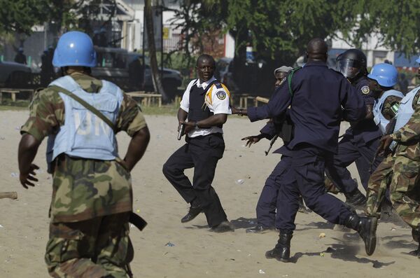 Um grupo de soldados nigerianos da missão da ONU, UNMIL, e de policiais liberianos perseguem um comandante d apolícia da Libéria que tinha disparado contra manifestantes da oposição em 7 de novembro de 2011, na véspera das eleições presidenciais no país - Sputnik Brasil