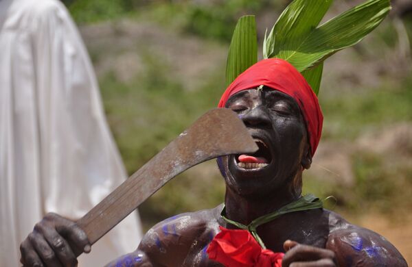 Um homem liberiano participa da cerimônia tradicional de homenagem pelas pessoas mortas da doença provocada pelo vírus ebola, em 7 de março de 2015, na capital da Libéria; cerimônias tradicionais têm sido muito criticadas pela comunidade internacional por favorecer contágio - Sputnik Brasil