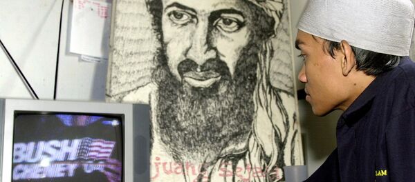 Um jovem muçulmano indonésio assiste a uma cobertura televisiva das eleições nos EUA na frente do retrato de Osama bin Laden, 03 de novembro de 2004 - Sputnik Brasil