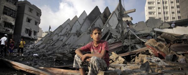 Menino palestiniano sentado sobre ruínas depois de bombardeio da Faixa de Gaza por Israel, agosto de 2014 - Sputnik Brasil