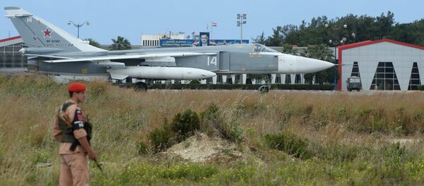 Um militar russo e o avião Su-24 na pista da base aérea de Hmeymim, Síria - Sputnik Brasil