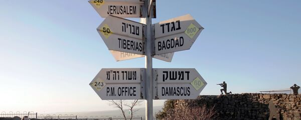 Israelis walk near a sign for tourists showing the distance to Damascus and Baghdad among other destinations at an army post on Mount Bental in the Israeli-annexed Golan Heights on March 10, 2016. - Sputnik Brasil