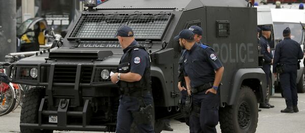 A polioce patrol looks at an armoured police vehicle parked in front of the train station in Lille, France. - Sputnik Brasil