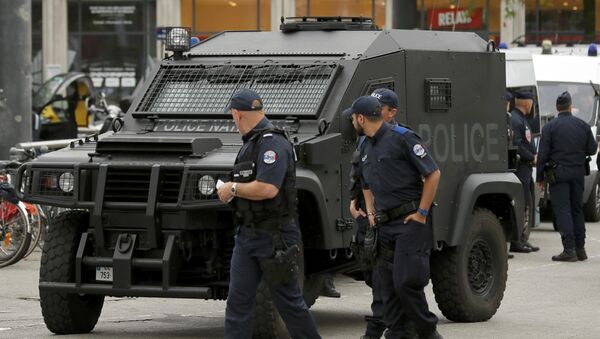 A polioce patrol looks at an armoured police vehicle parked in front of the train station in Lille, France. - Sputnik Brasil