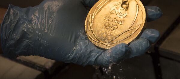 Um trabalhador limpa uma medalha de ouro dos Jogos Olímpicos no Rio 2016 após seu banho de ouro em uma fábrica de moeda no Rio de Janeiro Um trabalhador limpa uma medalha de ouro dos Jogos Olímpicos no Rio 2016 após seu banho de ouro em uma fábrica de moeda no Rio de Janeiro - Sputnik Brasil