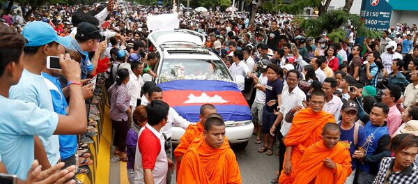 Um carro fúnebre carregando o corpo de Kem Ley, uma figura anti-governo e o cabeça de um grupo Khmer para Khmer, é cercado por seus partidários no caminho de um pagode para uma cerimônia budista depois que foi disparado morto em Phnom Penh. 10, julho, 2016. - Sputnik Brasil