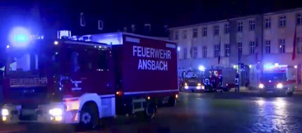 In this image taken from video fire trucks and ambulances stand in the city center of Ansbach near Nuremberg, southern Germany, Monday morning, July 25, 2016, after a man was killed when an explosive device he was believed to be carrying went off near an open-air music festival, injuring 12 others. - Sputnik Brasil
