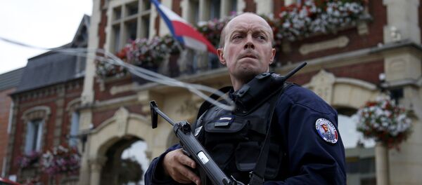 Um policial mantém vigilância em frente à prefeitura após dois assaltantes tomarem cinco reféns na igreja de Saint-Etienne-du -Rouvray, na Normandia, França, 26 de julho de 2016. - Sputnik Brasil