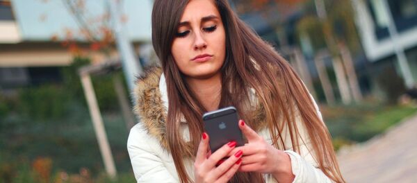 Uma menina usa seu celular - Sputnik Brasil