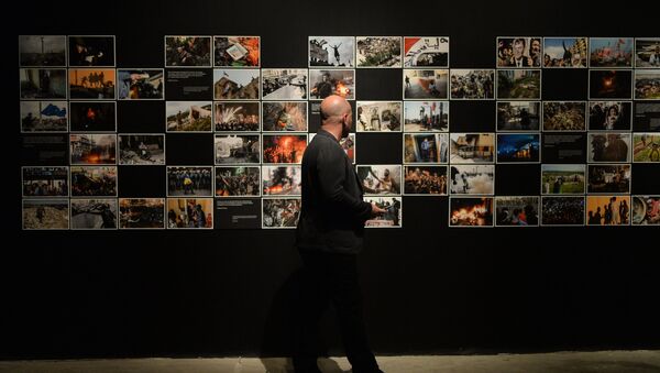 Visitante na exposição de fotos que foram premiados no Concurso Jornalístico Fotográfico Internacional Andrei Stenin 2015, Moscou, Rússia - Sputnik Brasil