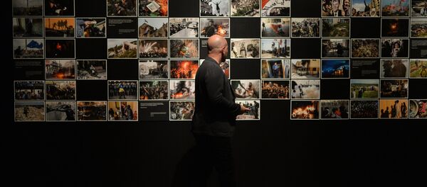 Visitante na exposição de fotos que foram premiados no Concurso Jornalístico Fotográfico Internacional Andrei Stenin 2015, Moscou, Rússia - Sputnik Brasil