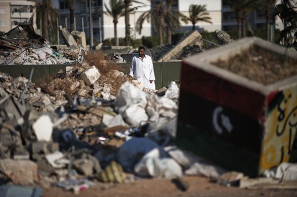 Homem passeia o local onde ficava a residência do líder líbio Muammar Kadhafi em Tripoli, Líbia, junho de 2012 - Sputnik Brasil