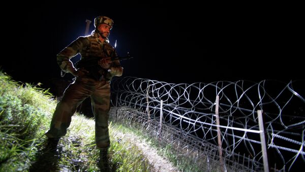 In this Dec. 22, 2013 photo, an Indian army soldier stands guard along barbed wire near the Line of Control (LOC), that divides Kashmir between India and Pakistan, at Krishna Ghati (KG Sector) in Poonch, 290 kilometers (180 miles) from Jammu, India - Sputnik Brasil