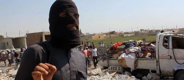 Um militante do Estado Islâmico caminha sobre escombros na Síria. - Sputnik Brasil