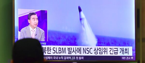 Homem vê notícias na TV sul-coreana sobre o lançamento de míssil balístico norte-coreano (foto de arquivo) - Sputnik Brasil