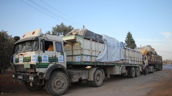 Trucks carrying aid are seen on the side of the road in the town of Orum al-Kubra on the western outskirts of the northern Syrian city of Aleppo on September 20, 2016, the morning after a convoy delivering aid was hit by a deadly air strike - Sputnik Brasil