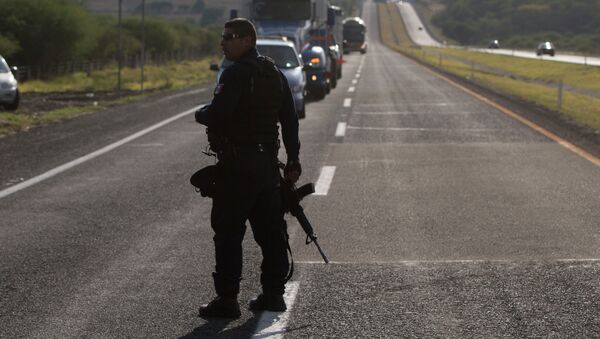 Mexican state police stop traffic, near the entrance of Rancho del Sol, near Ecuanduero, in western Mexico, Friday, May 22, 2015 - Sputnik Brasil