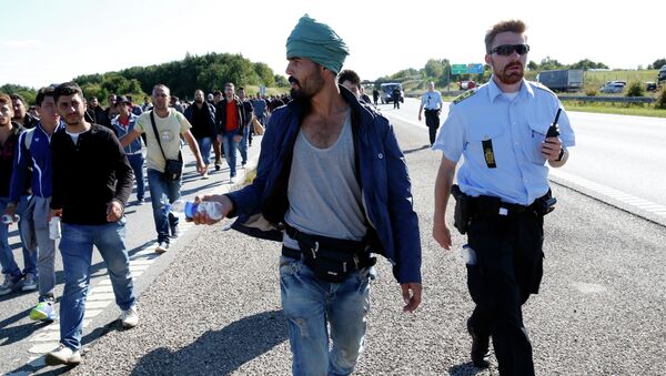 Migrants walk north on the highway in Southern Denmark, Wednesday, Sept. 9, 2015 - Sputnik Brasil