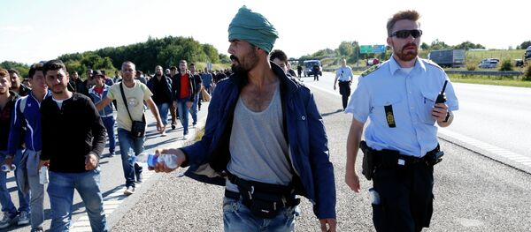 Migrants walk north on the highway in Southern Denmark, Wednesday, Sept. 9, 2015 Migrants walk north on the highway in Southern Denmark, Wednesday, Sept. 9, 2015 - Sputnik Brasil