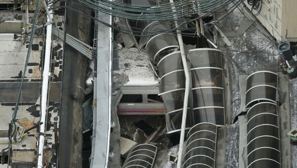 A derailed New Jersey Transit train is seen under a collapsed roof after it derailed and crashed into the station in Hoboken, New Jersey, U.S. September 29, 2016 - Sputnik Brasil