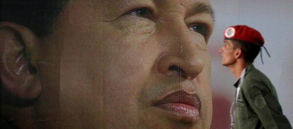 Soldado em frente do retrato do ex-presidente venezuelano Hugo Chávez - Sputnik Brasil