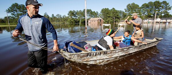 Socorristas evacuam família na Carolina do Norte, EUA, após a passagem do furacão Matthew - Sputnik Brasil