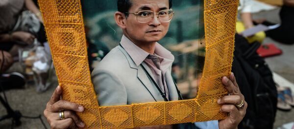 Apoiante do rei da Tailândia, Bhumibol Adulyadej, segura um retrato do rei perante o hospital Sriraj em Bangkok, Tailândia, 10 de outubro de 2016 - Sputnik Brasil