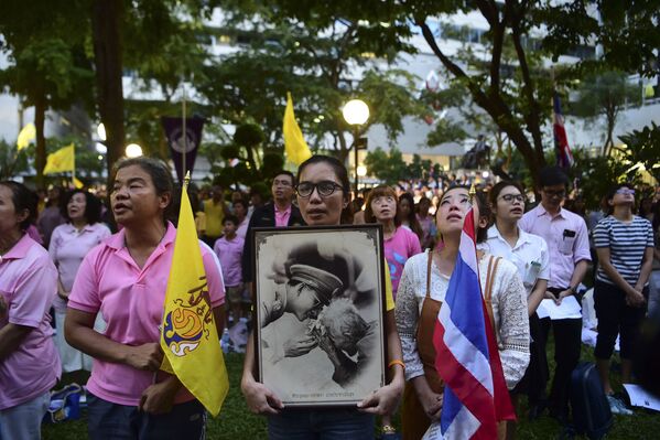 O rei da Tailândia, Bhumibol Adulyadej, faleceu no dia 13 de outubro, aos 88 anos de idade. Na foto: tailandeses seguram retrato do monarca enquanto esperam perto do hospital, em Bangkok, onde estava internado. - Sputnik Brasil