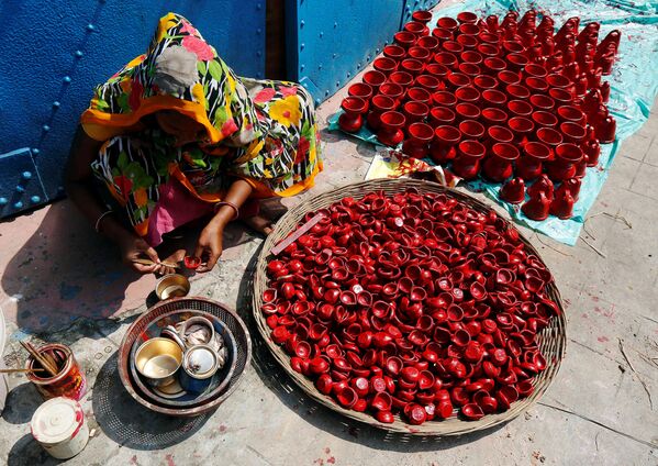 Uma mulher pinta lamparinas de barro usadas para decorar templos e casas durante o Diwali, o maior festival de fogos hindu em Kolkata, Índia, 17 de outubro de 2016 - Sputnik Brasil