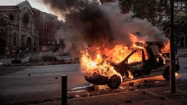 Carro da polícia sul-africana é incendiado em meio aos protestos de estudantes universitários pela educação superior gratuita - Sputnik Brasil
