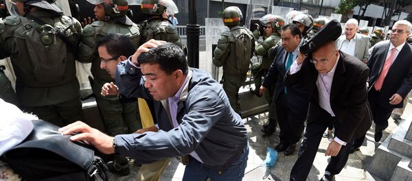 Parlamentares da oposição venezuelana se protegem enquanto tentam chegar à Assembleia Nacional em Caracas, 27 de outubro de 2016. Parlamentares da oposição venezuelana se protegem enquanto tentam chegar à Assembleia Nacional em Caracas, 27 de outubro de 2016. - Sputnik Brasil