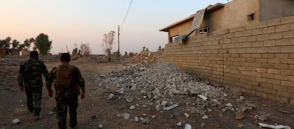 Combatentes de peshmerga passam um edifício destruido no leste de Mossul, Iraque, 26 de outubro de 2016 - Sputnik Brasil