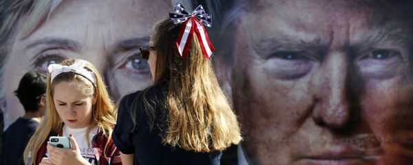 People pause near a bus adorned with large photos of candidates Hillary Clinton and Donald Trump before the presidential debate. People pause near a bus adorned with large photos of candidates Hillary Clinton and Donald Trump before the presidential debate. - Sputnik Brasil