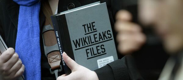 Simpatizante do fundador do WikiLeaks Julian Assange segurando uma cópia do The WikiLeaks Files - Sputnik Brasil