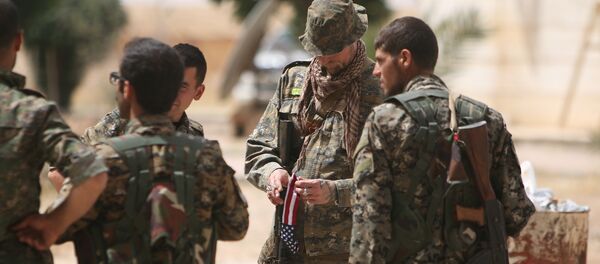 Um combatente norte-americano, que está lutando ao lado das Forças Democráticas da Síria, segura bandeira do seu país - Sputnik Brasil