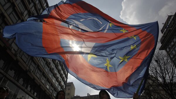 Homem acena com uma bandeira contra a OTAN e União Europeia em Belgrado, Sérvia, 27 de março de 2016 - Sputnik Brasil