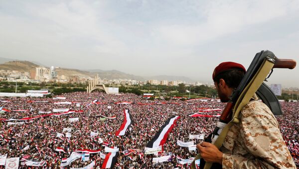 A soldier looks at people rallying to show support to a political council formed by the Houthi movement and the General People's Congress party to unilaterally rule Yemen by both groups, in the capital Sanaa August 20, 2016 - Sputnik Brasil