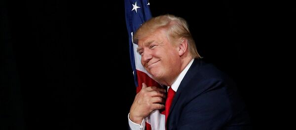 Donald Trump abraçando bandeira dos EUA - Sputnik Brasil