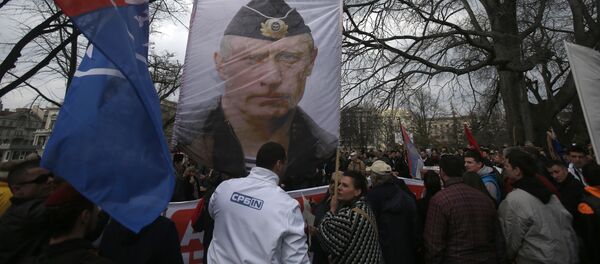 Manifestantes empunham o retrato do presidente russo Vladimir Putin durante um protesto contra a OTAN no centro de Belgrado, Sérvia, fevereiro de 2016 - Sputnik Brasil