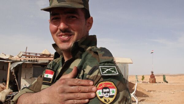 Soldado do Exército Sírio com o retrato do presidente Bashar Assad perto da fronteira líbano-síria - Sputnik Brasil