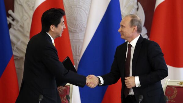 Premiê japonês Shinzo Abe apertando a mão do presidente russo Vladimir Putin - Sputnik Brasil