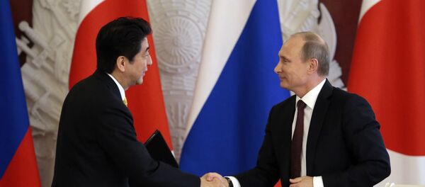 Premiê japonês Shinzo Abe apertando a mão do presidente russo Vladimir Putin - Sputnik Brasil