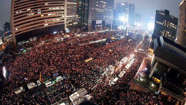 Sul-coreanos seguram velas durante uma manifestação contra a presidente Park Geun-hye em uma das avenidas principais de Seul, Coreia do Sul, 26 de novembro de 2016 - Sputnik Brasil