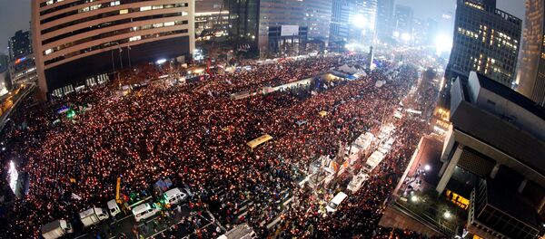 Sul-coreanos seguram velas durante uma manifestação contra a presidente Park Geun-hye em uma das avenidas principais de Seul, Coreia do Sul, 26 de novembro de 2016 - Sputnik Brasil